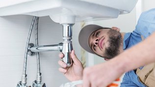 Ein Monteur unter einem Waschbecken