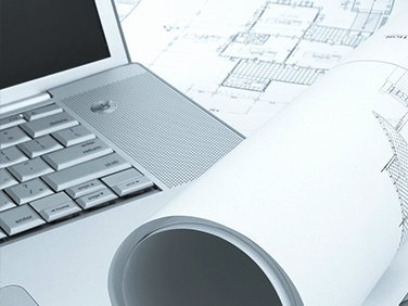 Bauzeichnungen und ein Laptop